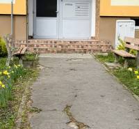 REZERVOVANÉ  3-izbový byt | Škultétyho ulica,  77,4 m², Trebišov. , - Vchod do budovy na Škultétyho ulici v Trebišove s lavičkami a záhonmi kvetov.