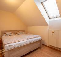 Predaj priestranného rodinného domu v historickej časti Popradu  - Svetlá spálňa v rodinnom dome s manželskou posteľou a strešným oknom.