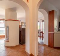 Predaj priestranného rodinného domu v historickej časti Popradu  - Interiér rodinného domu s tehlovou dlažbou, oblúkovými priechodmi a bielym krbom.