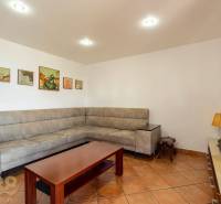 Predaj priestranného rodinného domu v historickej časti Popradu  - Obývacia izba v rodinnom dome s rohovou sedačkou a keramickou podlahou.