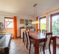 Predaj priestranného rodinného domu v historickej časti Popradu  - Interiér rodinného domu: jedáleň s veľkým stolom, stoličkami a klavírom.