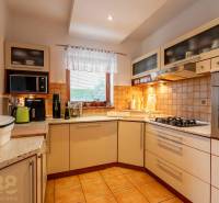 Predaj priestranného rodinného domu v historickej časti Popradu  - Kuchyňa v rodinnom dome so zabudovanými spotrebičmi, keramickým drezom a oknom.