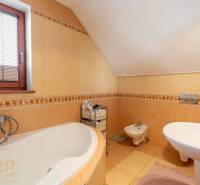 Predaj priestranného rodinného domu v historickej časti Popradu  - Kúpeľňa v rodinnom dome s vaňou, bidetom a oknom s žalúziami.