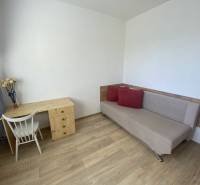 PRENÁJOM - 4 - izbový byt Košice - Západ, Obchodná ulica  - Obývacia izba v 4-izbovom byte so stolom, stoličkou a pohovkou. Podlaha s dreveným dekorom.