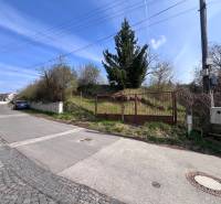 STAVEBNÝ POZEMOK S DUŠOU LEN PÁR MINÚT OD BRATISLAVY V OBCI MARIANKA - Pozemok na bývanie na Budovateľskej ulici v Marianke s bránou a príjazdovou cestou.