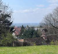 STAVEBNÝ POZEMOK S DUŠOU LEN PÁR MINÚT OD BRATISLAVY V OBCI MARIANKA - Záhrady s výhľadom medzi stromami a strechami na Budovateľskej ulici, Marianka, Pozemky - bývanie.