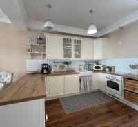 PREDAJ, 3 izb. byt v novostavbe PANORÁMA, 5 min. od AUPARKU - Kuchyňa s drevenými prvkami, bielymi skrinkami a keramickými obkladačkami v 3-izbovom byte na ulici Borievkova.