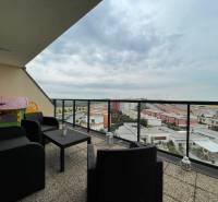 PREDAJ, 3 izb. byt v novostavbe PANORÁMA, 5 min. od AUPARKU - Balkón s výhľadom na ulici Borievkova, súčasť 3-izbového bytu, sedenie a detský domček.