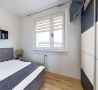 REZERVOVANÉ !!!  EXKLUZÍVNE: Štýlový 2,5-izbový byt s panoramatickým v - Spálňa s posteľou a televízorom, podlaha s dreveným dekorom v 3-izbovom byte.