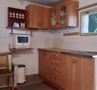 Záhradná chatka, Žilina - Dubeň - Kuchynka na chate s dreveným nábytkom a mikrovlnkou, podlaha s dreveným dekorom.