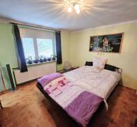 RODINNÝ DOM - HORNÉ OZOROVCE-POZEMOK 566 m2- 3,5 IZBOVÝ/ GARÁŽ - Spálňa v rodinnom dome s posteľou, zelenými stenami a podlahou s dreveným dekorom.