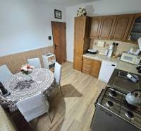 RODINNÝ DOM - HORNÉ OZOROVCE-POZEMOK 566 m2- 3,5 IZBOVÝ/ GARÁŽ - Kuchyňa v rodinnom dome s dreveným dekorom a jedálenským stolom.