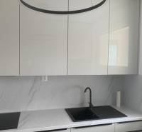 Predaj 2 izbového bytu, Drotárska cesta, Bratislava - Kuchyňa s bielymi skriňami a mramorovou pracovnou doskou v 2-izbovom byte.