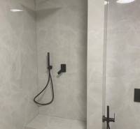 Predaj 2 izbového bytu, Drotárska cesta, Bratislava - Sprchový kút v 2-izbovom byte s čiernou batériou a kamennou stenou.