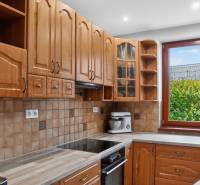 Rodinný dom s veľkým pozemkom a priestorom na podnikanie – T.Jastrabie - Kuchyňa v rodinnom dome s dreveným dekorom a výhľadom cez okno na zeleň.