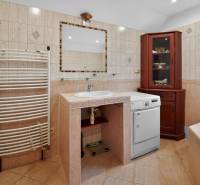 Rodinný dom s veľkým pozemkom a priestorom na podnikanie – T.Jastrabie - Kúpeľňa v rodinnom dome s práčkou, umývadlom, zrkadlom a dreveným nábytkom.