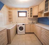 Rodinný dom s veľkým pozemkom a priestorom na podnikanie – T.Jastrabie - Kúpeľňa s vaňou, práčkou a kuchynskou linkou v rodinnom dome s modrým obkladom.