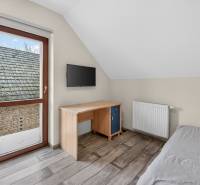 Rodinný dom s veľkým pozemkom a priestorom na podnikanie – T.Jastrabie - Jednoduchá izba v rodinnom dome s písacím stolom a televízorom na stene.