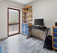 Rodinný dom s veľkým pozemkom a priestorom na podnikanie – T.Jastrabie - Pracovňa s modrým nábytkom, počítačom a podlahou s dreveným dekorom v rodinnom dome.