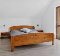 Rodinný dom s veľkým pozemkom a priestorom na podnikanie – T.Jastrabie - Spálňa v rodinnom dome s drevenou posteľou, podlaha s dreveným dekorom.