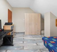 Rodinný dom s veľkým pozemkom a priestorom na podnikanie – T.Jastrabie - Pracovňa s počítačovým stolom, pohovkou a podlahou s dreveným dekorom v rodinnom dome.