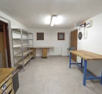 Rodinný dom s veľkým pozemkom a priestorom na podnikanie – T.Jastrabie - Dielňa s pracovnými stolmi a regálovými policami v rodinnom dome.