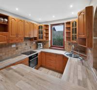 Rodinný dom s veľkým pozemkom a priestorom na podnikanie – T.Jastrabie - Kuchyňa v rodinnom dome s drevenými skrinkami a pracovnou doskou s dreveným dekorom.