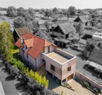 Rodinný dom s veľkým pozemkom a priestorom na podnikanie – T.Jastrabie - Rodinný dom v Trenčianskom Jastrabí, s červenou strechou a zelenou záhradou.