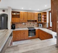 Rodinný dom s veľkým pozemkom a priestorom na podnikanie – T.Jastrabie - Kuchyňa v rodinnom dome s drevenými skrinkami a podlahou s dreveným dekorom.