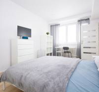 NA PREDAJ,2-IZBOVÝ TEHLOVÝ BYT,KOŠICE-SEVER,LOMNICKÁ UL. - Svetlá spálňa s posteľou, zrkadlom, komodou a podlahou s dreveným dekorom.