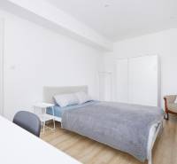 NA PREDAJ,2-IZBOVÝ TEHLOVÝ BYT,KOŠICE-SEVER,LOMNICKÁ UL. - Spálňa 2-izbového bytu s posteľou, skriňou a podlahou s dreveným dekorom.