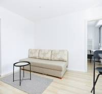 NA PREDAJ,2-IZBOVÝ TEHLOVÝ BYT,KOŠICE-SEVER,LOMNICKÁ UL. - Obývací priestor s pohovkou, stolíkom a podlahou s dreveným dekorom v 2-izbovom byte.