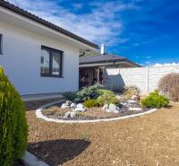 NOVOSTAVBA BUNGALOVU S MNOŽSTVOM PRIESTORU, v slepej ulici, Pružina - Záhrada pri rodinnom dome v Pružine s okrasnými kríkmi a živým plotom.