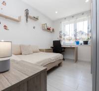 NOVOSTAVBA BUNGALOVU S MNOŽSTVOM PRIESTORU, v slepej ulici, Pružina - Detská izba v rodinnom dome s posteľou, písacím stolom a podlahou s dreveným dekorom.