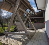 NOVOSTAVBA BUNGALOVU S MNOŽSTVOM PRIESTORU, v slepej ulici, Pružina - Na záhrade rodinného domu v Pružine je drevená hojdačka pod prístreškom.