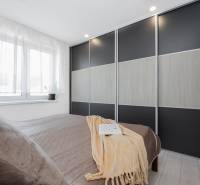 NOVOSTAVBA BUNGALOVU S MNOŽSTVOM PRIESTORU, v slepej ulici, Pružina - Spálňa v rodinnom dome s veľkou vstavanou skriňou a posteľou.