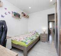 NOVOSTAVBA BUNGALOVU S MNOŽSTVOM PRIESTORU, v slepej ulici, Pružina - Detská izba v rodinnom dome s posteľou, písacím stolom a knihami na poličkách.