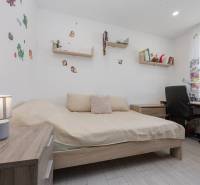 NOVOSTAVBA BUNGALOVU S MNOŽSTVOM PRIESTORU, v slepej ulici, Pružina - Detská izba v rodinnom dome s posteľou, písacím stolom a dekoráciami na stene.