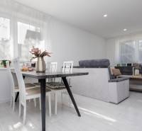 NOVOSTAVBA BUNGALOVU S MNOŽSTVOM PRIESTORU, v slepej ulici, Pružina - Jedáleň v rodinnom dome s podlahou s dreveným dekorom, svetlými stoličkami a pohovkou.