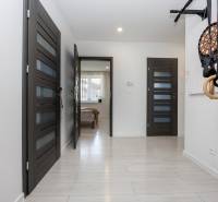 NOVOSTAVBA BUNGALOVU S MNOŽSTVOM PRIESTORU, v slepej ulici, Pružina - Chodba s dverami, podlahou s dreveným dekorom a cvičebným náradím v rodinnom dome.