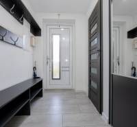 NOVOSTAVBA BUNGALOVU S MNOŽSTVOM PRIESTORU, v slepej ulici, Pružina - Vstupná hala s vešiakmi a lavičkou v rodinnom dome, svetlé dlaždice na podlahe.