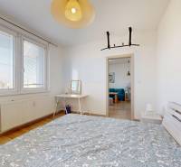 Pekný 2-izbový byt s lodžiou | investičná príležitosť | - Spálňa s dvojlôžkom, stolíkom a podlahou s dreveným dekorom v 2-izbovom byte.