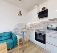 Pekný 2-izbový byt s lodžiou | investičná príležitosť | - Kuchyňa v 2-izbovom byte so sedačkou, barovým pultom a podlahou s dreveným dekorom.