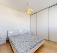 Pekný 2-izbový byt s lodžiou | investičná príležitosť | - Spálňa s manželskou posteľou, vstavanou skriňou a podlahou s dreveným dekorom v 2-izbovom byte.