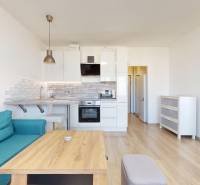 Pekný 2-izbový byt s lodžiou | investičná príležitosť | - Obývacia izba s kuchynským kútom a podlahou s dreveným dekorom v 2-izbovom byte.