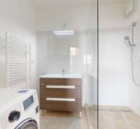 | Priestranný 2,5-izb. byt s walk-in šatníkom | parkovanie | - Kúpeľňa v 2-izbovom byte s práčkou, sprchovým kútom a umývadlom.