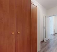 | Priestranný 2,5-izb. byt s walk-in šatníkom | parkovanie | - Vstupná hala 2-izbového bytu s podlahou s dreveným dekorom a drevenou skriňou.
