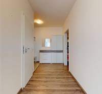 | Priestranný 2,5-izb. byt s walk-in šatníkom | parkovanie | - Chodba s podlahou s dreveným dekorom a šatníkovou skriňou v 2-izbovom byte.