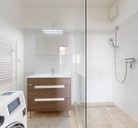 | Priestranný 2,5-izb. byt s walk-in šatníkom | parkovanie | - Kúpeľňa v 2-izbovom byte s minimalistickým zariadením, so sprchou a práčkou.