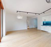 | Prémiové bývanie v ZWIRNe I Pekný 2i byt I  - Priestranný obývací priestor s podlahou s dreveným dekorom a kuchynským kútom v 2-izbovom byte.